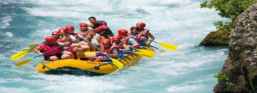 A group of people enjoying a thrilling adventure as they navigate down a river on a raft.